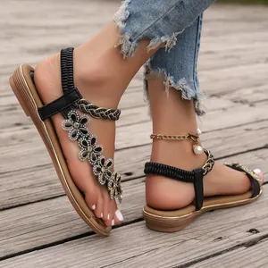 Close-up of black summer sandals with rhinestone flower embellishments and elastic strap