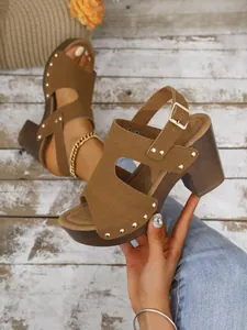 Stijlvolle bruine suède sandalen met blokhak, gouden klinknagels en verstelbare riem