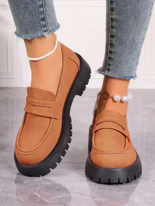 Detailed view of women's stylish camel suede platform loafers with thick black lug soles