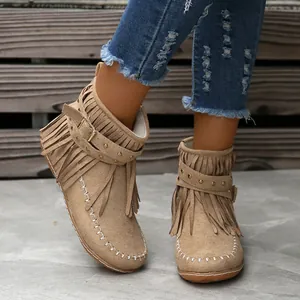 Vista detallada de botines de ante con flecos para mujer con remaches y costuras.