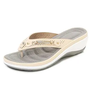 Zijaanzicht van elegante beige dames slippers met sleehak en strass metalen gesp