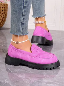 Side view detail of pink suede platform loafers with thick black chunky soles