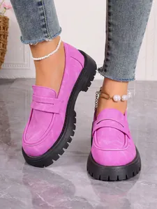 Detailed view of fashionable pink suede loafers with a chunky black platform sole