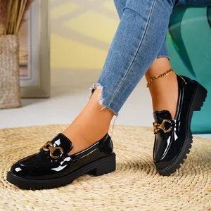 Elegant black patent leather loafers for women with thick soles and gold buckle detail