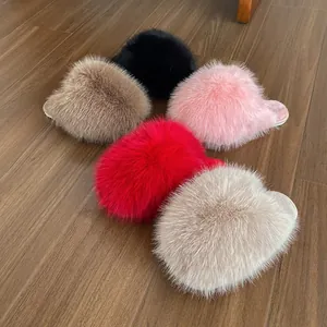 Detailed view of fluffy faux fur home slippers in multiple colors on a wood floor.