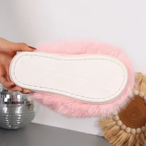 Detailed view of the anti-slip rubber sole on plush pink fuzzy slippers with size marking