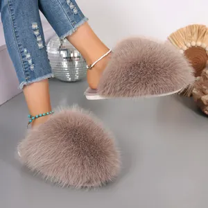 Detail view of plush taupe faux fur slippers featuring dense fluffy texture and soft white sole.