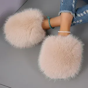 Close-up of plush oversized faux fur slippers in soft peach with warm winter lining