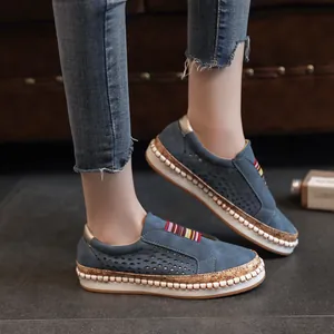 Zijaanzicht blauwe loafers met gatenpatroon, dikke kurkzool en decoratieve stiksels