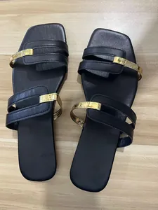 Top-down view of black flat sandals for women with stylish gold metallic strap accents