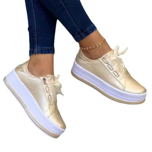 Stylish women's gold platform sneakers featuring a round toe and elegant lace-up design