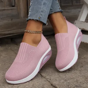 Detailed close-up of pink fly-knit walking sneakers featuring a cushioned sole and gold anklet