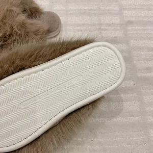 Close-up detail of a fluffy faux fur slipper showing non-slip sole texture and plush material