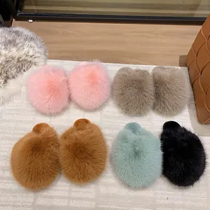 Assorted colors of fluffy faux fur house slippers displayed on a cozy textured rug