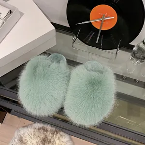 Detail view of fluffy light green faux fur slippers with a soft and warm texture