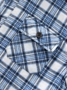 Close-up detail of the button-down chest pocket on a blue and white plaid flannel shirt