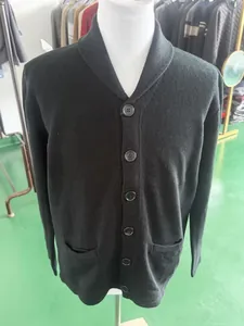 Detailed view of men's black knit cardigan with shawl collar and buttons.