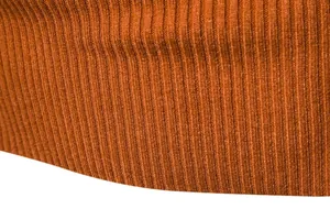 Macro dettaglio del tessuto a maglia a coste arancio bruciato con trama morbida e fine.