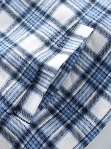 Macro detail shot showing blue and white plaid pattern and fabric texture of men's flannel shirt