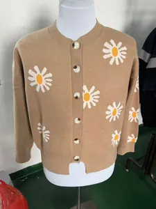 Detailed view of camel daisy pattern knitted cardigan with marbled brown buttons