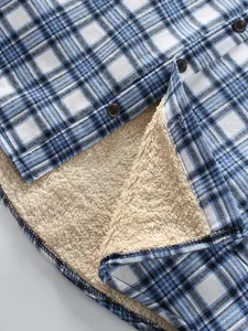 Detailed macro view of men's blue plaid shirt with warm beige sherpa fleece lining.