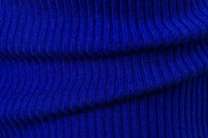 Macro primo piano della morbida trama a maglia a coste blu reale di un maglione da uomo.