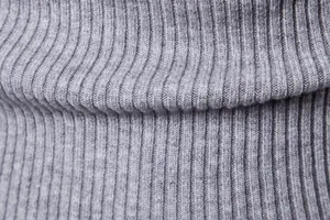 Dettaglio macro della trama del tessuto a maglia a coste grigio per maglione da uomo.