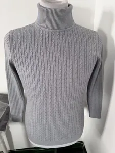 Detailed view of grey men's turtleneck sweater featuring an intricate cable knit pattern.