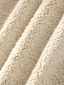 Macro view of the soft cream sherpa fleece lining used in warm men's winter jackets