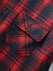 Macro close-up of red and black plaid shirt fabric texture and chest pocket button detail