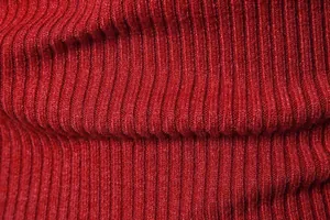 Vista macro che mostra la trama dettagliata del tessuto a maglia a coste rosse da uomo