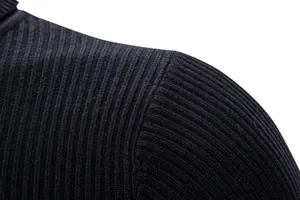 Vista dettagliata della trama a maglia a coste nere e della cucitura della spalla di un maglione