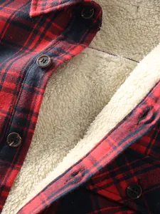 Macro view of men's red plaid shirt featuring thick sherpa lining and buttons