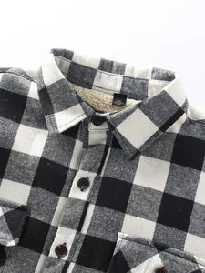 Close-up detail of men's black and white checkered flannel shirt with warm fleece lining