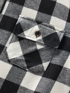 Close-up of chest pocket and button on black and white buffalo plaid flannel shirt