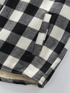 Close-up of black and white plaid shirt showing sherpa lining and pocket detail.