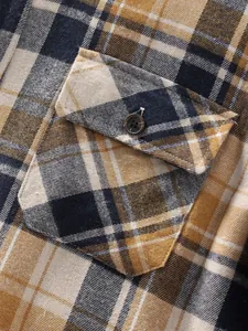Detailed view of flap pocket and button on men's brown plaid flannel shirt jacket.