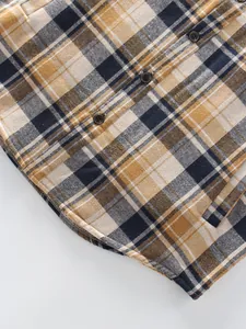 Close-up detail of yellow and navy blue plaid shirt showing fabric texture and buttons