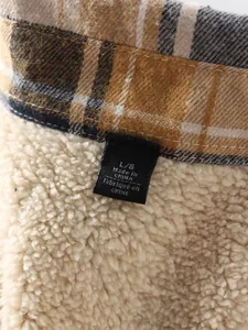 Macro view of men's autumn plaid shirt showing thick warm fleece lining and neck label