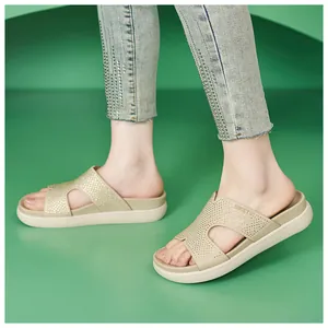 Detalle de sandalias de plataforma beige con pedrería brillante en los pies