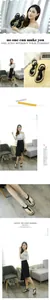 Elegant black T-strap flat sandals with metal ring detail and white contrast stitching