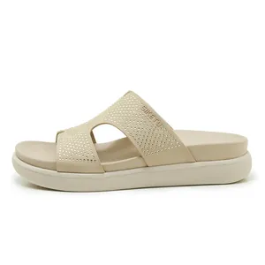 Vista lateral de sandalias de plataforma beige con tiras adornadas con strass.