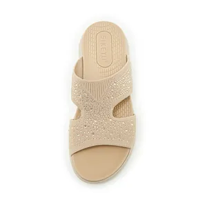 Draufsicht auf bequeme beige Keilpantoletten mit Fly-Knit-Gewebe und glitzernden Strasssteinen