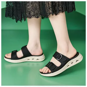 Side view of black double-strap slide sandals with chunky hollowed-out soles on model