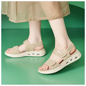 Vista dettagliata di eleganti sandali beige con zeppa, cinturini in tessuto e velcro