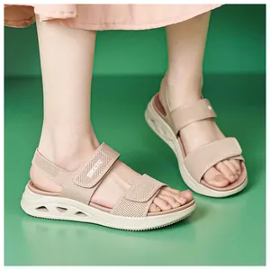 Dettaglio di sandali beige con zeppa in tessuto fly-woven con velcro e tomaia in rete.