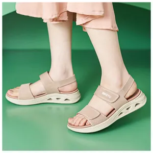 Dettaglio di sandali beige in fly-knit da donna con suole platform e chiusura velcro