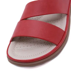 Close-up detail of red leather toe straps and perforated breathable insole of sandals