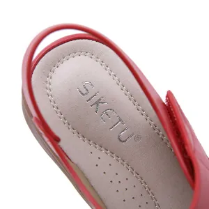 Macro view of SIKETU brand logo printed on the soft cushioned insole of red wedge sandals