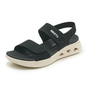 Dettaglio di sandali neri in tessuto fly-knit con chiusura in velcro e suola platform